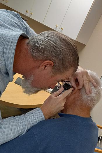 Eric examining patient's ear canal